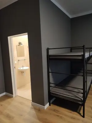 a room with a bunk bed and a bathroom with a sink at Centro Hostel in Vilnius