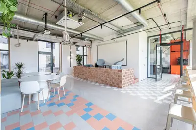 a room with a table and chairs and a brick wall at SHED Vilnius Coliving in Vilnius