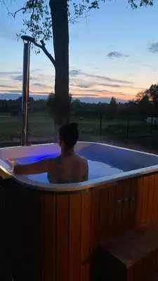 a man in a jacuzzi tub with a tree at Lake House in Anykščiai