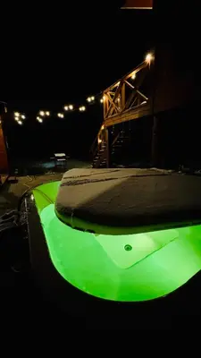 a green swimming pool with a ramp in the dark at Lake House in Anykščiai