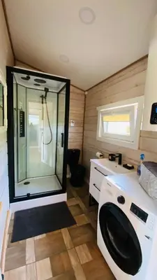 a bathroom with a shower and a washing machine at Lake House in Anykščiai