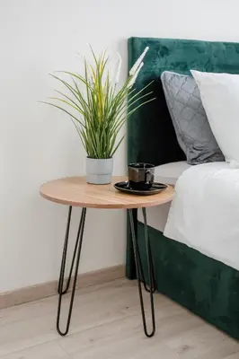 a table with a plant on it next to a bed at Stylish Apartment in Zverynas in Vilnius