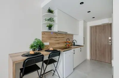 a kitchen with a wooden counter and stools at Stylish Apartment in Zverynas in Vilnius