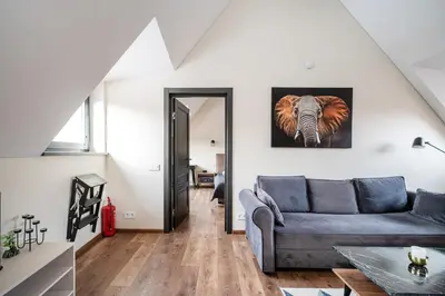 a living room with a couch and an elephant picture on the wall at Cozy Central Attic SELF Check In in Vilnius