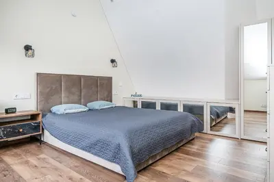 a bedroom with a large bed with blue pillows at Cozy Central Attic SELF Check In in Vilnius