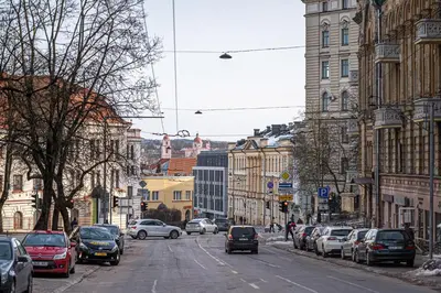 a busy city street with cars parked on the street at Cozy Central Attic SELF Check In in Vilnius