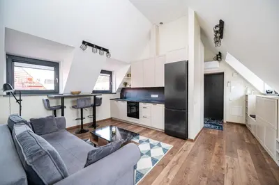 a living room with a couch and a kitchen at Cozy Central Attic SELF Check In in Vilnius