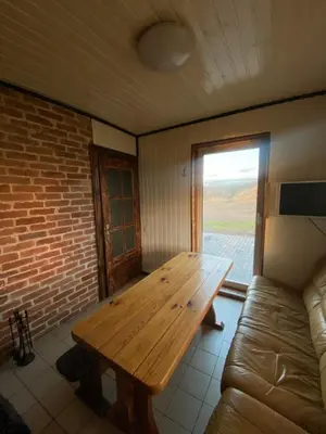 a wooden table in a room with a couch at Homestead - Ukmergė area in Pabariškiai