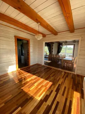 a room with a wooden floor and a dining room at Homestead - Ukmergė area in Pabariškiai
