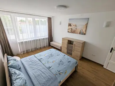 a bedroom with a bed and a dresser and a window at Lovely 2-bedroom flat in the heart of Druskininkai in Druskininkai