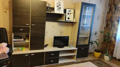 a room with a desk with a tv and a cabinet at Rami nakvynė Panevėžyje in Panevėžys