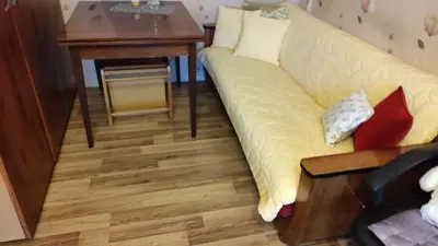 a living room with a couch and a table at Rami nakvynė Panevėžyje in Panevėžys