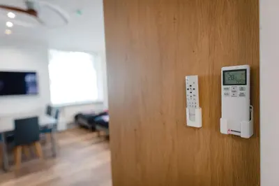 a door with a clock on it and a room at Birch Alley Self Check-In in Panevėžys