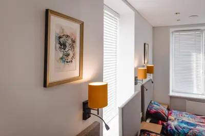 a living room with a couch and a picture on the wall at Birch Alley Self Check-In in Panevėžys