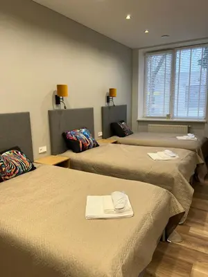 a room with three beds with towels on them at Birch Alley Self Check-In in Panevėžys