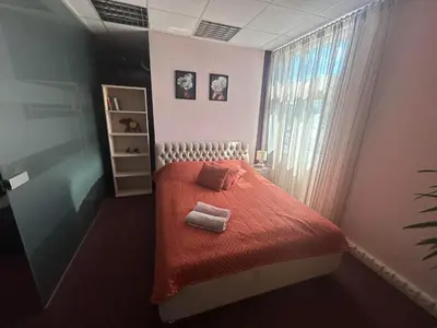 a bedroom with a bed with red sheets and a window at Draugystės apartmentai in Kaunas