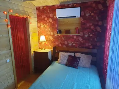 a bedroom with a blue bed and a red wall at The Archers House in Viktariškės