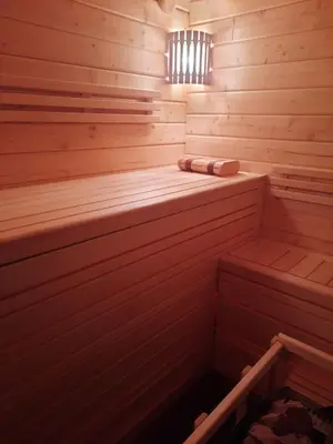 a wooden sauna with a bench in the middle at The Archers House in Viktariškės