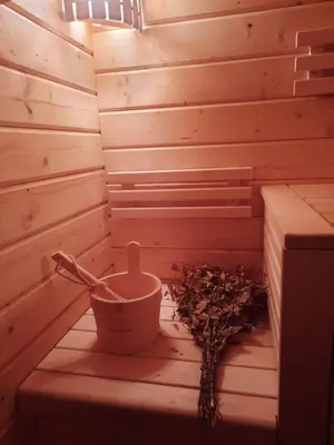 a sauna with a bucket and a pot on a table at The Archers House in Viktariškės