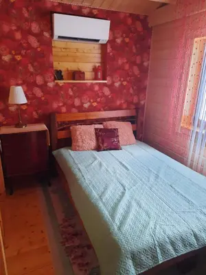 a bedroom with a bed with a blue comforter and a window at The Archers House in Viktariškės