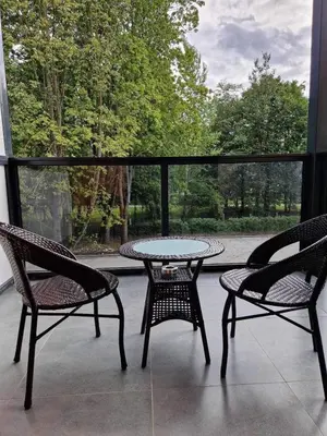 a patio with two chairs and a table and a table and chairs at Parko nauji apartamentai in Panevėžys