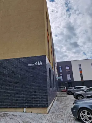 a building with a sign on the side of it at Parko nauji apartamentai in Panevėžys