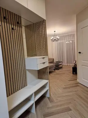 a living room with a couch and a chandelier at Parko nauji apartamentai in Panevėžys