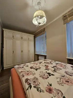 a bedroom with a bed with a floral bedspread at Vilnius City Walls apartment in Vilnius