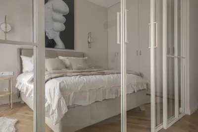 a white bedroom with a bed with glass doors at IVIS House - Elegant Apartment with Church View in Vilnius Old Town in Vilnius