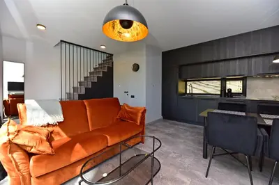 an orange couch in a living room with a table at Premium Forest Bungalow with Ofuro Tub in Luokesos Sen