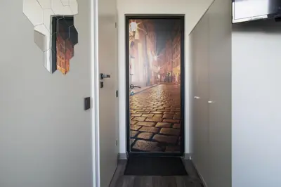 a door leading into a hallway with a painting of a street at Vilnius4you studio in Vilnius
