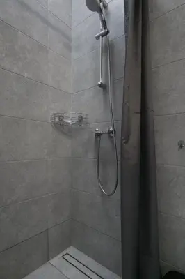 a shower with a shower curtain in a bathroom at Vilnius4you studio in Vilnius