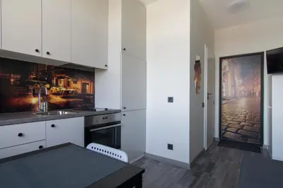 a kitchen with white cabinets and a black table at Vilnius4you studio in Vilnius