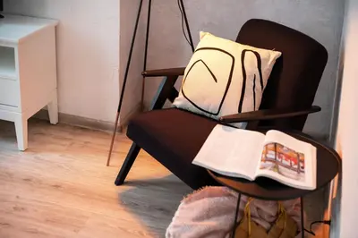 a black chair with a pillow and a newspaper at #stayhere - Cozy 1BDR Apartment Vilnius Old Town in Vilnius