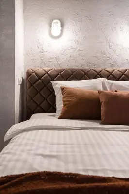 a bed with white sheets and brown pillows at #stayhere - Cozy 1BDR Apartment Vilnius Old Town in Vilnius