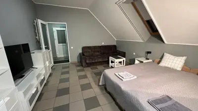 a small bedroom with a bed and a couch at Klykių apartamentai in Klykiai