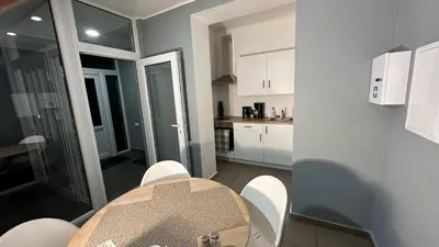 a small kitchen with a table and chairs in a room at Klykių apartamentai in Klykiai