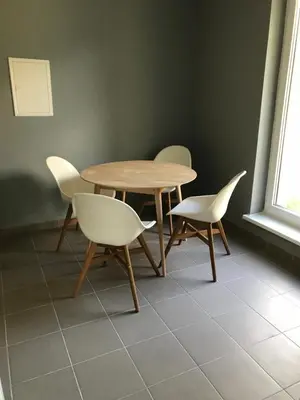 a wooden table and chairs in a room with a window at Klykių apartamentai in Klykiai