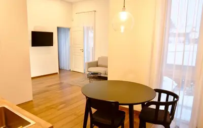 a living room with a table and chairs and a couch at Žalio kalno apartamentai in Kaunas