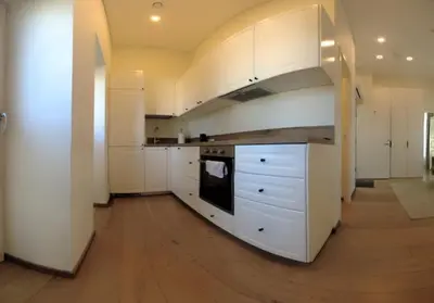 a kitchen with white cabinets and a stove top oven at Žalio kalno apartamentai in Kaunas