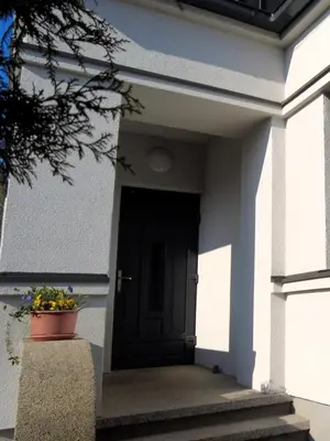 a black door of a house with a potted plant at Žalio kalno apartamentai in Kaunas