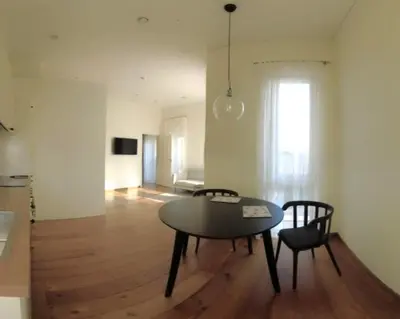a dining room with a table and chairs in a room at Žalio kalno apartamentai in Kaunas