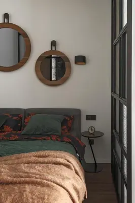 a bedroom with a bed and two mirrors on the wall at IVIS House - Stylish and Original Apartment in Vilnius Old Town in Vilnius