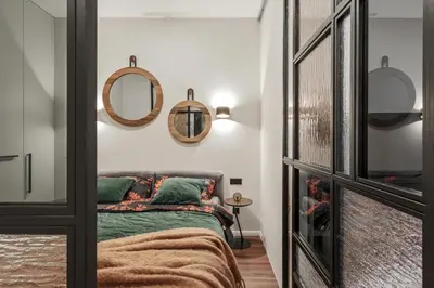 a guest bedroom with a bed and mirrors at IVIS House - Stylish and Original Apartment in Vilnius Old Town in Vilnius