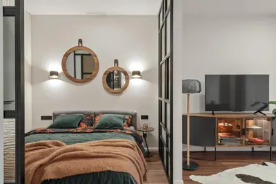 a bedroom with a bed and a tv and mirrors at IVIS House - Stylish and Original Apartment in Vilnius Old Town in Vilnius