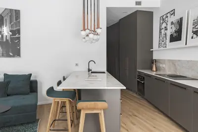 a kitchen with a sink and a counter with stools at IVIS House - Spacious Apartment with Terrace, Vilnius Old Town in Vilnius