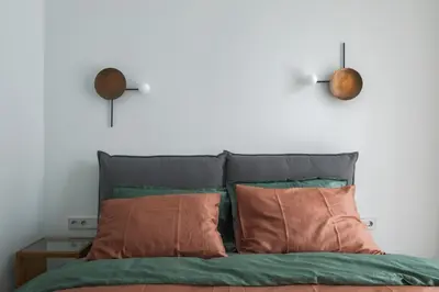 a bed with two pillows and a white wall at IVIS House - Spacious Apartment with Terrace, Vilnius Old Town in Vilnius