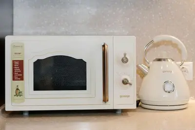 a white microwave sitting on a counter next to a blender at Luxury Old Town Apartment in Kaunas