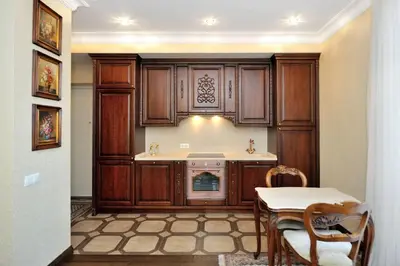 a kitchen with wooden cabinets and a table with chairs at Luxury Old Town Apartment in Kaunas