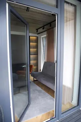 a sliding glass door of a living room with a couch at J. Ralio apartamentai in Vilnius